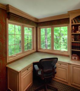 Infinity casement windows with interior light woodgrain frames that match the wood cabinets in a a home office
